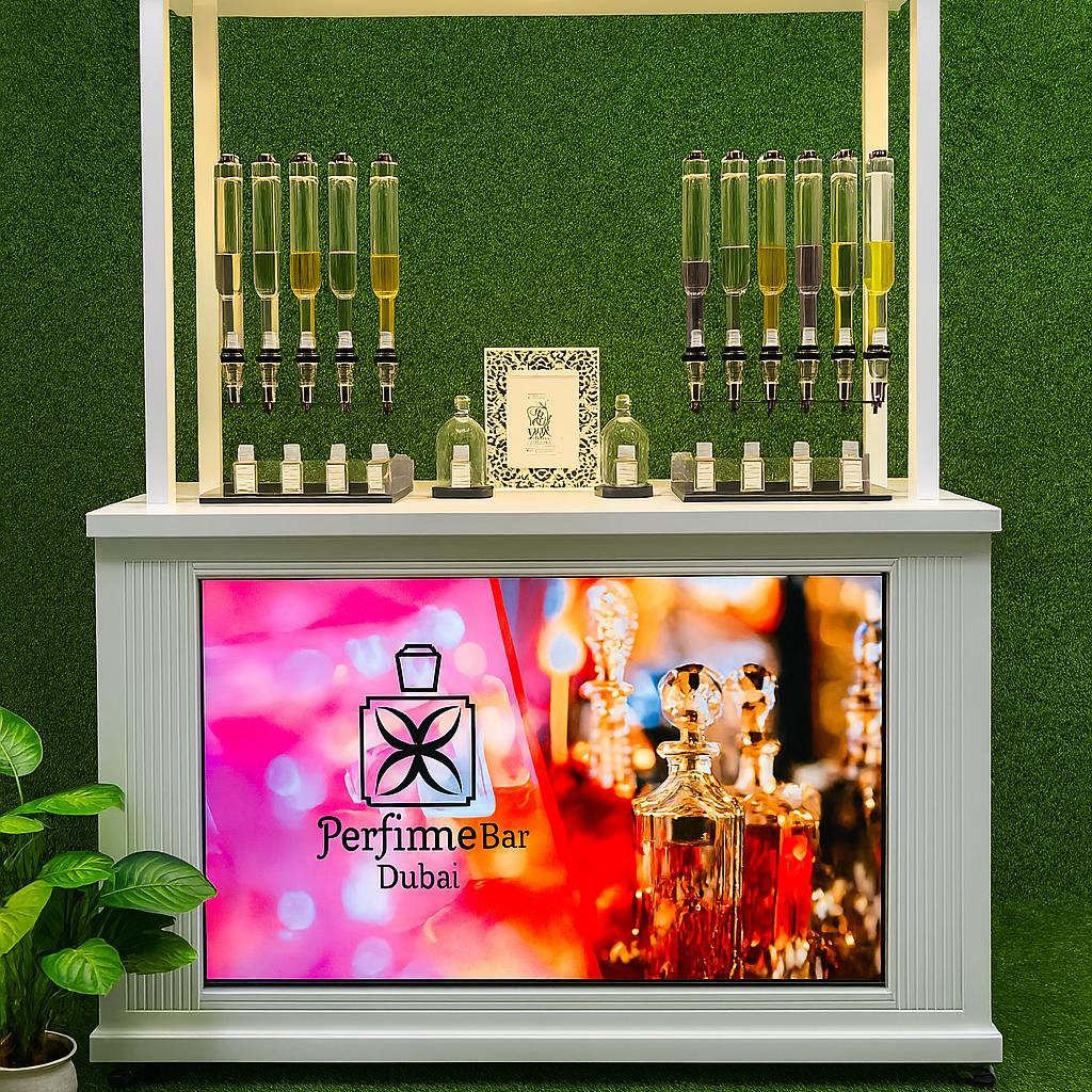 Perfume Booth setup in Dubai featuring a branded fragrance bar with colorful dispensers, interactive screen, and artificial grass backdrop for events and exhibitions